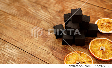 Coals for hookah on wooden background with dry oranges Coals for hookah on wooden background with dry oranges 72297252