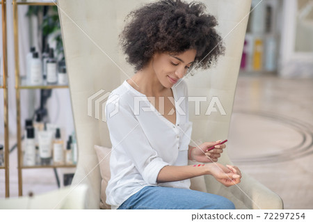 Girl looking at wrist testing lip pencil Girl looking at wrist testing lip pencil 72297254