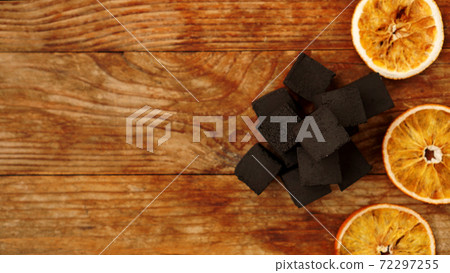 Coals for hookah on wooden background with dry oranges Coals for hookah on wooden background with dry oranges 72297255