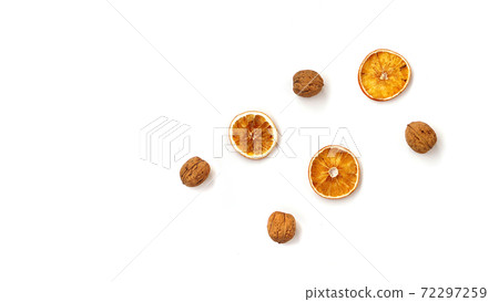 Walnuts and dry oranges on white background Walnuts and dry oranges on white background 72297259