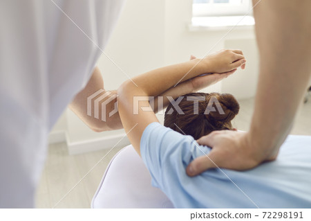 Hands of experienced masseur doctor osteopath fixing lying woman patients shoulder joint Hands of experienced masseur doctor osteopath fixing lying woman patients shoulder joint 72298191