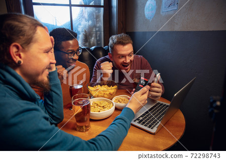 Excited fans with mobile app for betting and score on their devices. Gambling, emotions 72298743