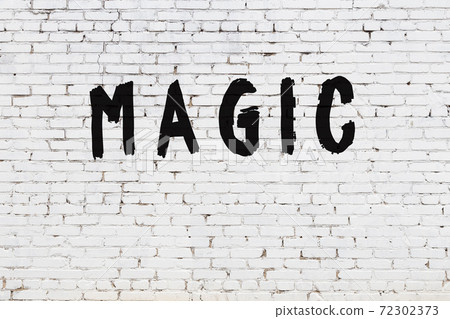 Word magic painted on white brick wall Word magic painted on white brick wall 72302373