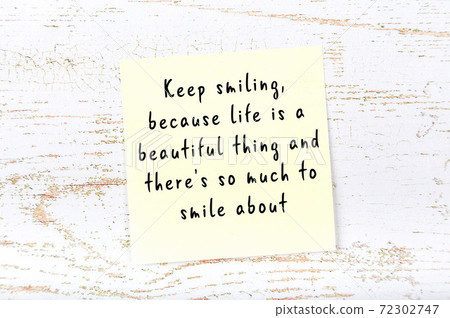 Yellow sticky note on wooden wall with wise quote 72302747