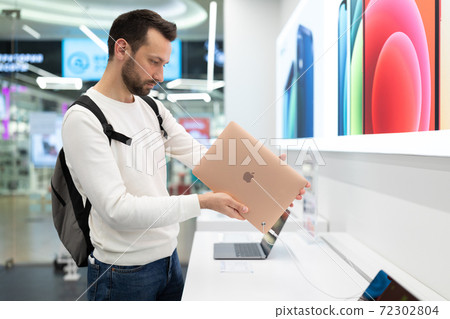 Belarus; December 05, 2020; a young man stands at a showcase with MacBook Air laptops in the Apple Belarus; December 05, 2020; a young man stands at a showcase with MacBook Air laptops in the Apple 72302804