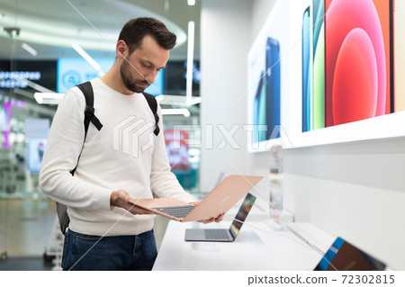 Belarus; December 05, 2020; a guy chooses a gift for a holiday, in an epl store he examines a 72302815
