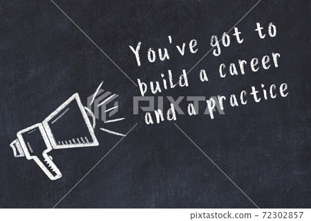 Chalk loudspeaker and wise quote on black desk 72302857