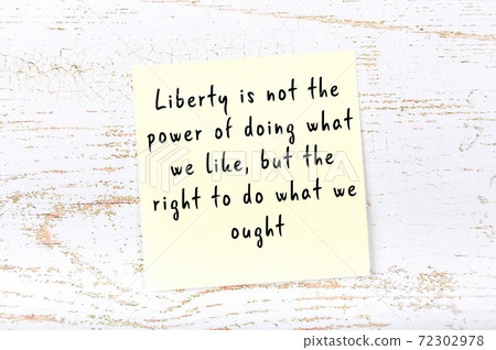 Yellow sticky note on wooden wall with wise quote Yellow sticky note on wooden wall with wise quote 72302978