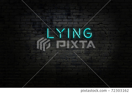Night view of neon sign on brick wall 72303162