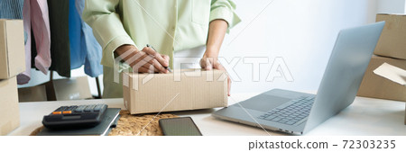 Business owner entrepreneur packing cardboard box preparing parcel for shipment, Online marketing.. Business owner entrepreneur packing cardboard box preparing parcel for shipment, Online marketing.. 72303235