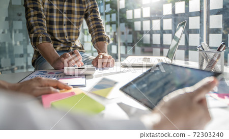 Startup business people teamwork calculating a valuation in workplace.. Startup business people teamwork calculating a valuation in workplace.. 72303240