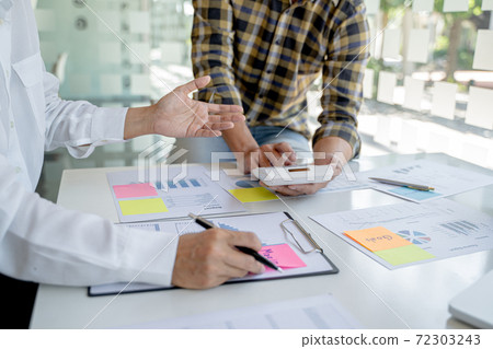 Startup business people teamwork calculating a valuation in workplace.. Startup business people teamwork calculating a valuation in workplace.. 72303243