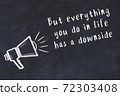 Chalk loudspeaker and wise quote on black desk 72303408