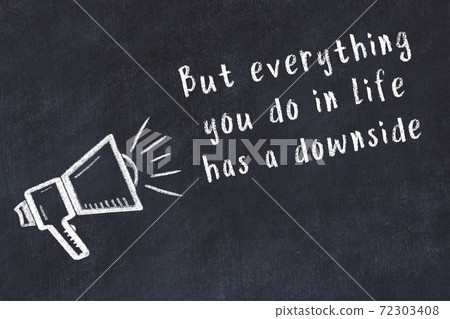 Chalk loudspeaker and wise quote on black desk 72303408