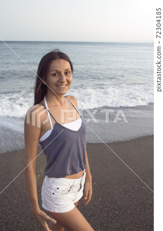Young woman on the beach in very positive and happy attitude 72304185