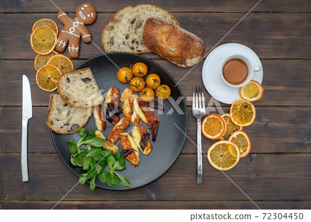 Dish with fried halloumi cheese and tomatoes on table 72304450