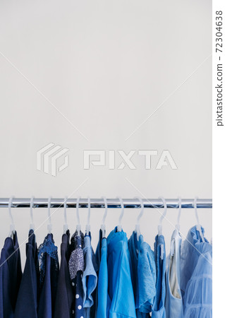 Fast fashion, Sustainable fashion, minimalist wardrobe. Variety of female blue clothing on hanging on white background with copy space. Fashion minimal style banner 72304638