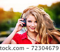 Woman with headphones listening summer music 72304679