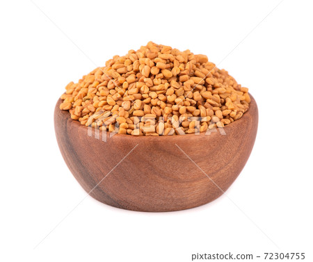 Fenugreek seeds in wooden bowl, isolated on white background. Shambala, helba seeds. 72304755