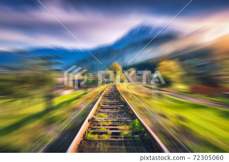 Railroad in mountains with motion blur effect at sunset in autumn 72305060