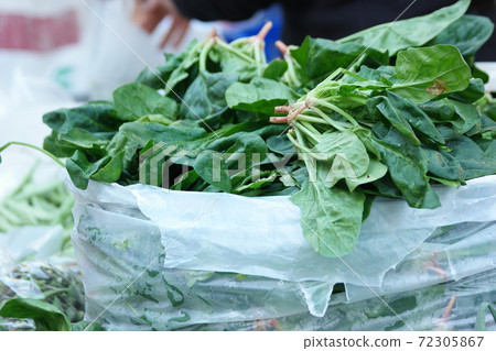 Fresh green spinach on sale at market stall. Fresh green spinach on sale at market stall. 72305867