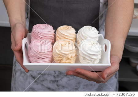 Homemade colorful marshmallows in the hands of a pastry chef. Appetizing dessert Homemade colorful marshmallows in the hands of a pastry chef. Appetizing dessert 72307150