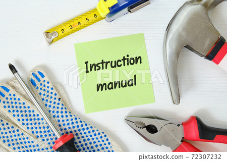 Concept of instruction manual on a sheet of paper next to work tools on a wooden background Concept of instruction manual on a sheet of paper next to work tools on a wooden background 72307232