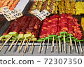 Different kind of meats on barbecue skewers are on the counter in a market in Thailand 72307350