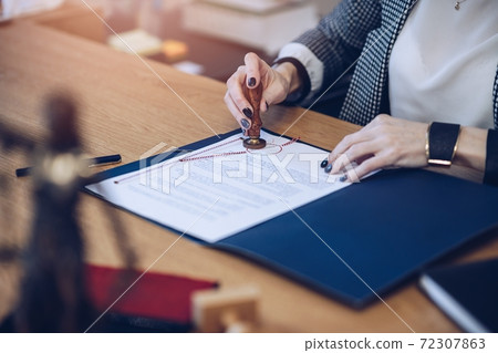 A woman notary, a lawyer stamps the seal on the notarial act. A woman notary, a lawyer stamps the seal on the notarial act. 72307863