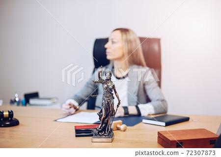 Female lawyer sitting at the wooden desk in the notary public office. 72307873