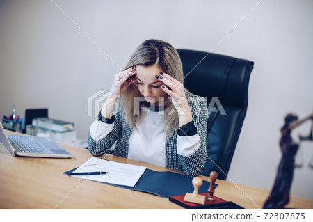 Concentrated female notary public carefully reads the notarial act Concentrated female notary public carefully reads the notarial act 72307875