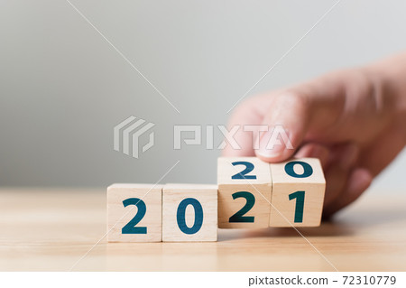 New year 2020 change to 2021 concept. Hand flip over wood cube block 72310779