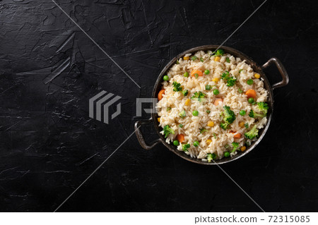 Vegan rice, stir fried, shot from the top on a black background Vegan rice, stir fried, shot from the top on a black background 72315085