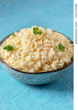 White rice in a bowl on a blue background, ser White rice in a bowl on a blue background, ser 72315086