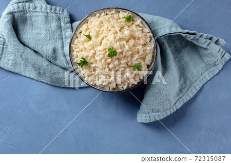 Rice with parsley, shot from the top on a blue background Rice with parsley, shot from the top on a blue background 72315087