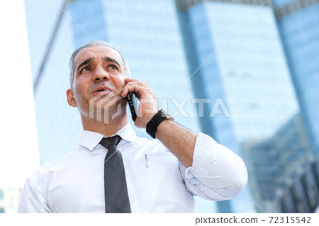stock trader, investor, businessman talking on the mobile phone as worried about trade war news and disappointed from losing stock market after checking investment portfolio. business and financial. 72315542