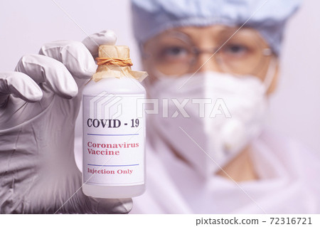 Female doctor holds bottle of vaccine covid-19. 72316721