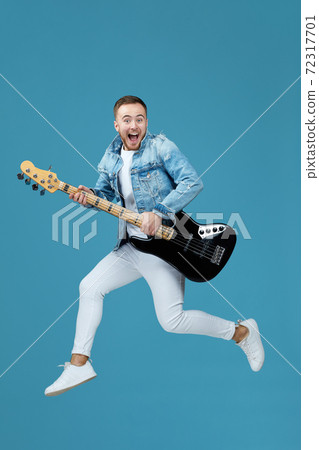 man in denim t-shirt jeans with guitar jumping 72317701