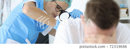 Practitioner doctor with magnifying glass in his hand examines rectum of man patient portrait Practitioner doctor with magnifying glass in his hand examines rectum of man patient portrait 72319686