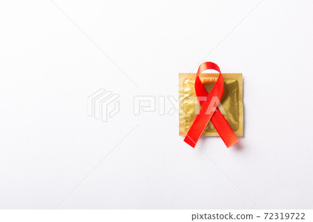 Red bow ribbon symbol HIV, AIDS cancer awareness and condom 72319722