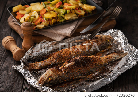 Homemade grilled labrax served with stewed vegetables. 72320276