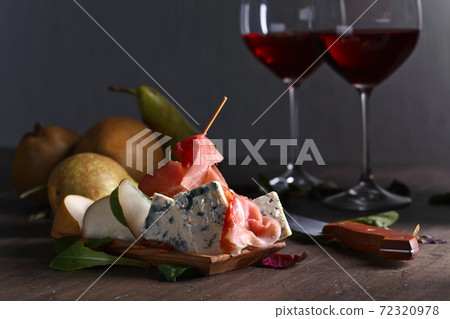 blue cheese with prosciutto , pear and red wine 72320978