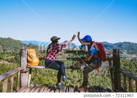 Asian couple Tourists with backpacks Happy to travel She raised her hand to make a heart shape and enjoy the natural scenery on the mountain. 72321965