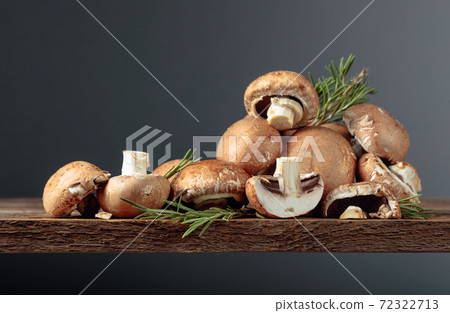 Fresh brown mushrooms champignon on a old wooden table. Fresh brown mushrooms champignon on a old wooden table. 72322713