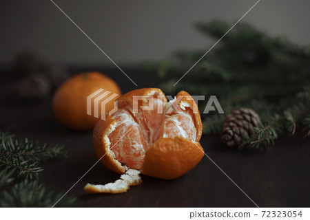 Tangerine on a wooden table, fir branches and cones. 72323054
