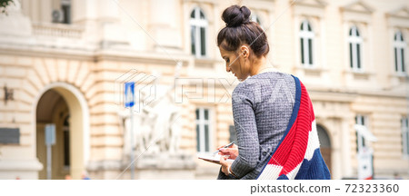 Student writes into a notebook 72323360