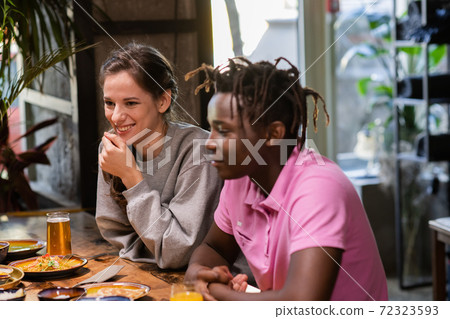 Happy young couple in cafe, having a great time with their frien 72323593