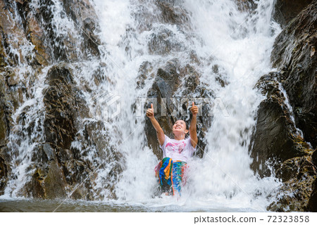 Girl traveling waterfall on holiday. The girl who is enjoying playing the waterfall happily. travel nature, Travel relax, travel Thailand. Huai Toh waterfall at Krabi. 72323858