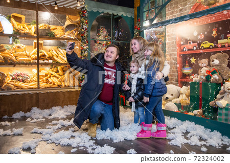 Family taking selfie near toy store together Family taking selfie near toy store together 72324002