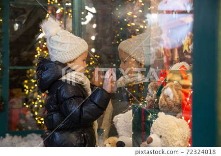 Curious child examining toys in shop window Curious child examining toys in shop window 72324018